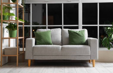 Yeşil bitkileri ve kanepesi olan modern mutfağın içi.