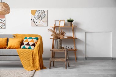 Rahat kanepesi, resimleri, yastıkları ve rafları olan güzel bir oturma odası.