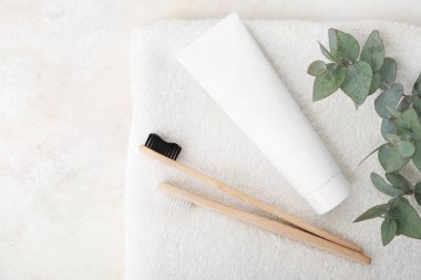 Tahta diş fırçaları, yapıştırıcı, temiz havlu ve okaliptüs dalı.