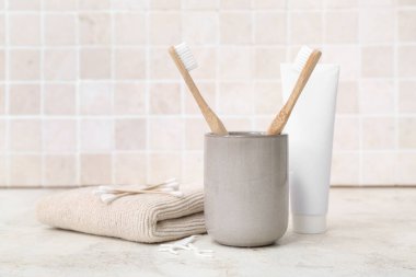 Bambu diş fırçasıyla banyo malzemelerini açık fayans duvarına dayayın.