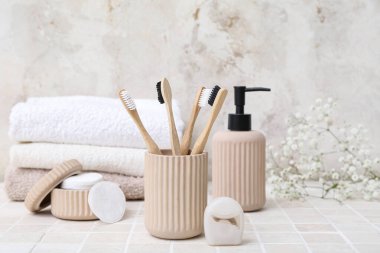 Bambu diş fırçasıyla aydınlık fayans masasında banyo malzemeleri.