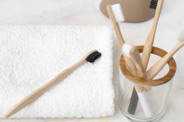 Bambu diş fırçaları ve arka planda temiz havlu olan tutucu, yakın plan.