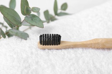 Bambu diş fırçası ve okaliptüs dalları hafif temiz havlu, yakın plan