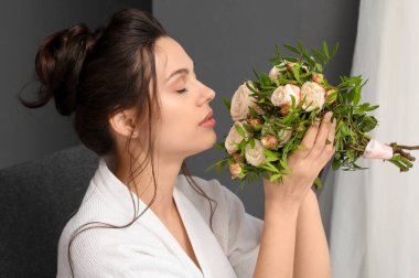 Soyunma odasında düğün buketi olan güzel genç gelin, yakın plan.