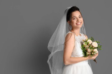 Koyu arkaplanda düğün buketi olan güzel bir gelin.