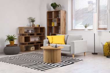 Rahat kanepesi, raf ünitesi, ev bitkileri ve sehpası olan modern bir oturma odası.