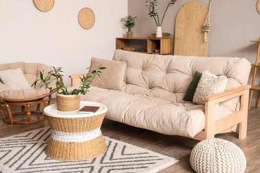 Kahve masasında, koltukta ve beyaz koltukta bambu sapları olan hafif oturma odasının şık bir iç mekanı.