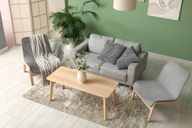 Kanepe, çiçek açan vazolar şık bir oturma odasının içindeki masanın üzerinde.