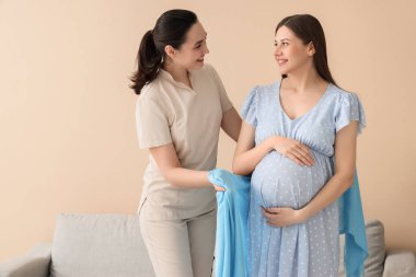 Doula hamile kadını eşarpla sarıyordu.