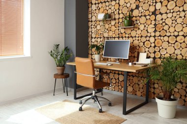 Çalışma alanı, raflar ve yeşil ev bitkileriyle birlikte ofis içi