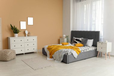 Yatağı, komodiniyle ve çekmeceleriyle şık bir yatak odası.