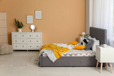 Yatağı, komodiniyle ve çekmeceleriyle şık bir yatak odası.