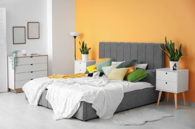 Yatağı, komodiniyle ve çekmeceleriyle şık bir yatak odası.