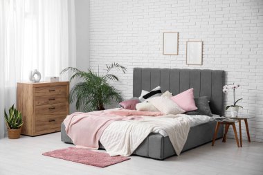 Yatak odası, komodinli yatak odası, çiçek ve ahşap çekmeceler.