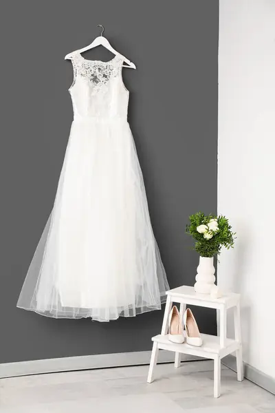 Schönes Hochzeitskleid Schuhe Und Strauß Der Nähe Der Grauen Wand Stockbild