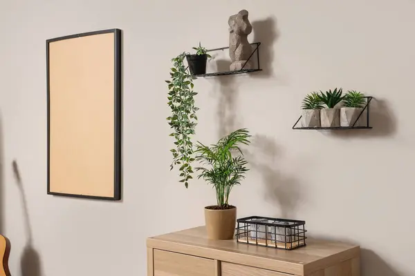 Regale Mit Grünen Pflanzen Und Statuette Heller Wand Wohnzimmer Stockfoto