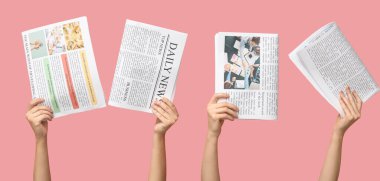 Hands with newspapers on pink background