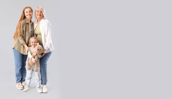 Маленькая девочка с мамой и бабушкой на сером фоне с местом для смс
