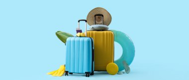 Mavi arkaplanda plaj aksesuarları ve metin için yeri olan bavullar