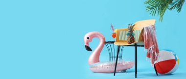 Mavi arkaplanda yazı için yeri olan sandalye ve plaj aksesuarları