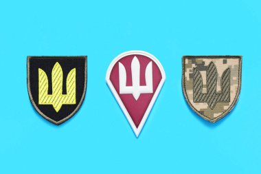 Mavi arka planda mızrağı olan Ukrayna ordusunun farklı askeri rozetleri.