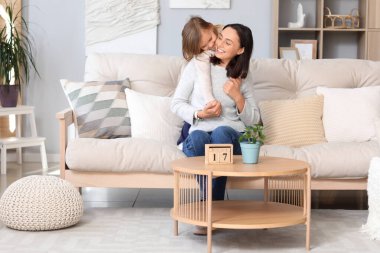 Güzel anne küçük tatlı kızıyla evde kucaklaşıyor.