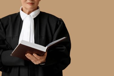 Female judge with book on brown background