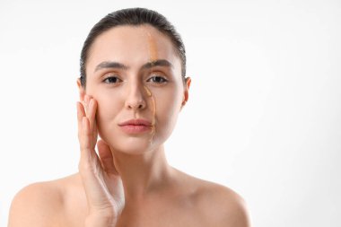 Young woman with dripping honey on her face against light background