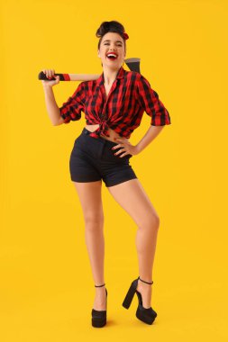 Sarı arka planda baltası olan genç bir poster kadını.