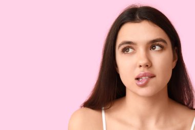 Pembe arka planda güzel dudakları olan genç bir kadın, yakın plan.