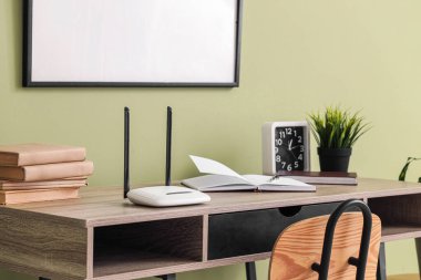 Ofiste kablosuz ağ yönlendiricisi ve kitapları olan bir işyeri