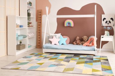 Şık çocuk odasının içi rahat yatak odası, oyuncaklar ve ahşap stadyumla dolu.