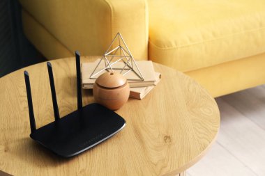 Modern Wi-Fi yönlendirici, oturma odasındaki masada kitaplar, yakın çekim.