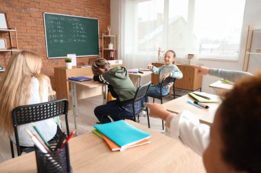 Okulda sınıf arkadaşlarına zorbalık eden küçük çocuklar.