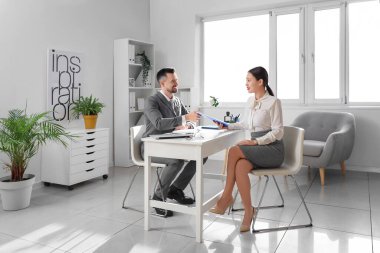 Female Asian applicant with human resources manager at job interview in office
