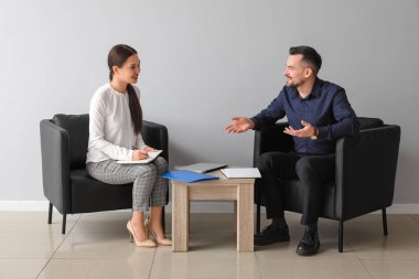 İnsan Kaynakları Yöneticisi başvuru sahibini ofisteki ışık duvarı yakınında sorguluyor.