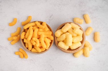 Farklı arkaplanda farklı lezzetli tuzlu mısır çubukları olan tahta kaseler.