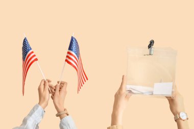 Oy sandığı olan eller ve bej arka planda ABD bayrakları. Seçim kavramı