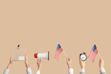 Oy sandığı olan eller, ABD bayrakları, megafon ve bej arka planda çalar saat. Seçim kavramı