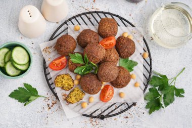 Hafif arkaplanda nefis falafel topları, nohut ve domatesin yanında dur.