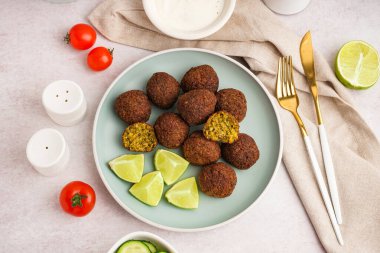 Nefis falafel köfteli, limonlu ve domatesli bir tabak.