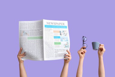 Female hands with newspaper, eyeglasses and cup of coffee on lilac background
