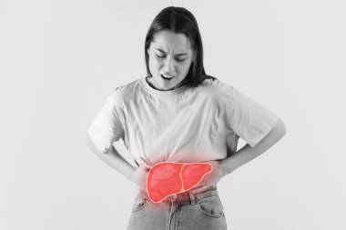 Young woman feeling discomfort in liver on light background