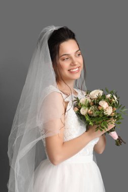 Koyu arkaplanda düğün buketi olan güzel bir gelin.