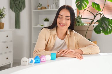Beautiful young happy woman with different dental floss in bathroom at home