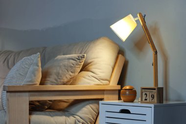 Geceleri oturma odasındaki masada, üzerinde küp takvim olan parlayan lamba.