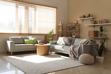 Interior of cozy living room with grey sofas, table and shelf units