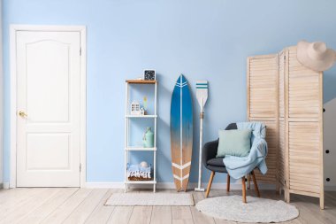 Gri koltuklu ve sörf tahtalı şık bir oturma odası.