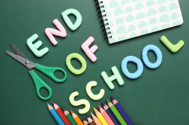 Okulun Metin Sonu, yeşil arkaplandaki kalem ve makas. Üst görünüm