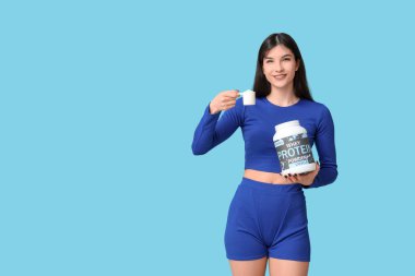Sporty young woman with bottle of protein powder and scoop on color background